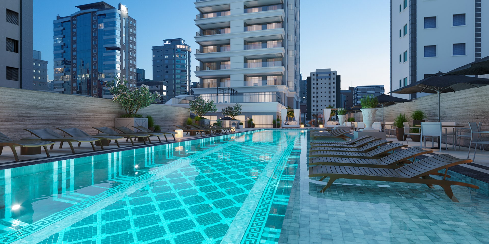 Piscina do L'Atelier Concept Homes ao anoitecer, com vista para o skyline de Meia Praia